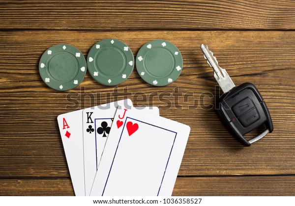 Cards, chips and car\
key, wooden background