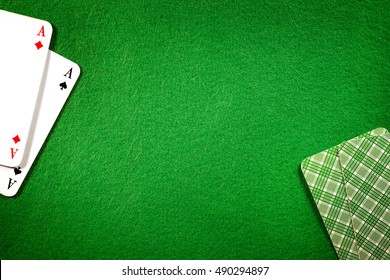 Cards on green felt casino table background. Two aces, copy space in center