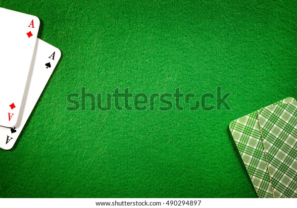 Cards on green felt casino table background. Two\
aces, copy space in\
center