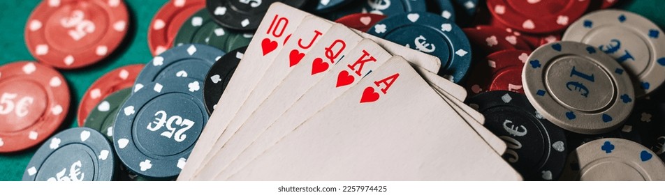 cards with Royal flush on the chips on the green table in the game of poker - Shutterstock ID 2257974425