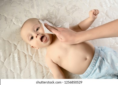 Care For Babe - Wiping The Baby Face Skin With Wet Wipes. Funny Baby Emotions. Baby Care Hygiene. Cleaning Wipe, Pure, Clean.