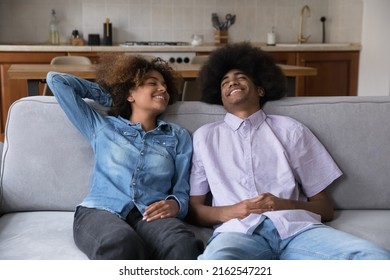 Care Free Happy Black Couple Of Teenagers Enjoying Leisure, Relaxing On Couch, Breathing Fresh Air With Closed Eyes, Laughing, Talking. Teen African Elder Brother And Sister Home Shot