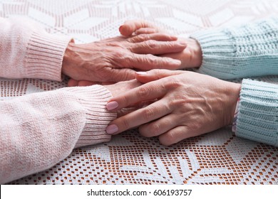 Care Is At Home Of Elderly. Holding Hands Closeup