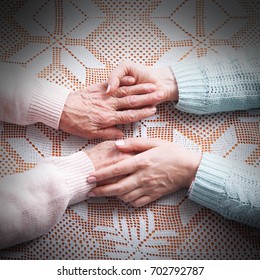 Care Is At Home Of Elderly. Holding Hands Closeup