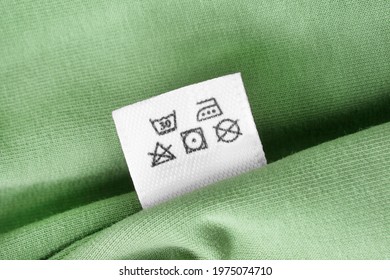 Care Instructions Clothing Label On Green Textile Background