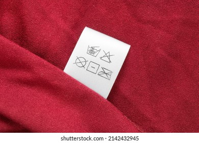 Care Instructions Clothing Label On Red Fabric Background