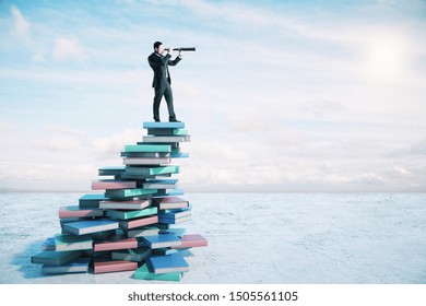 Career growth and development concept with businessman on book mountain looking through a telescope. - Shutterstock ID 1505561105