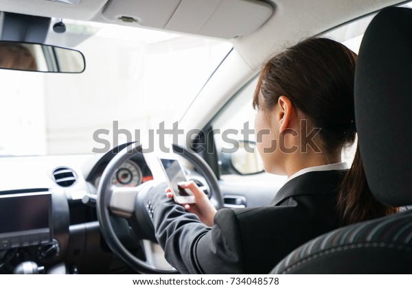 Career woman telephoning in\
car