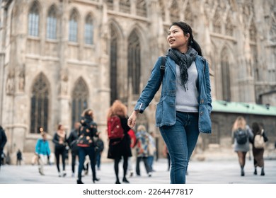 carefree Asian woman enjoy sight seeing travel in front of famous church in Vienna tour in downtown. Young woman exploring famous old architecture Stephansdom cathedral church in downtown