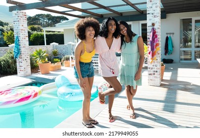 Carefree Biracial Millennial Female Friends Laughing While Enjoying By Pool During Weekend In Summer. Hangout, Happy, Unaltered, Friendship, Togetherness, Social Gathering, Enjoyment Concept.