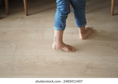 A carefree child walks barefoot on a wooden floor, cherishing innocence and exploration - Powered by Shutterstock