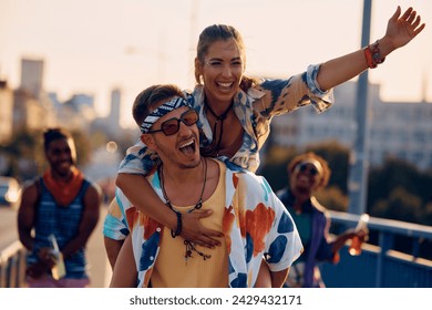 Carefree couple having fun and piggybacking while going on open air music festival in summer. - Powered by Shutterstock