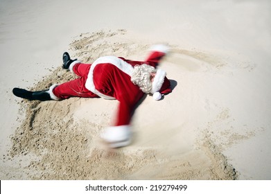 A Carefree Father Christmas Doing A Sand Angel On The Beach Sand With Copyspace