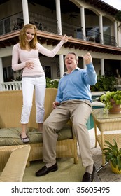 Carefree Father And Daughter Playing Air Guitar On Patio