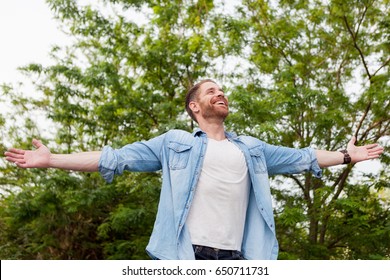 Carefree And Free Man Raising His Arms Surrounded Of Nature