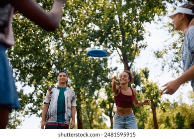 Carefree friends playing with frisbee in the park.  - Powered by Shutterstock