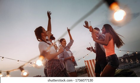 Carefree group of happy friends enjoying party on rooftop terrace - Powered by Shutterstock