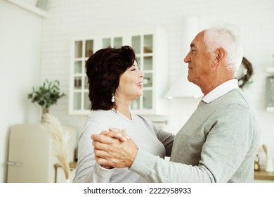 Carefree Happy Active Old Senior Couple Dancing In Kitchen