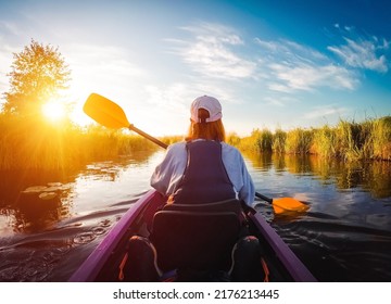 Carefree hipster girl enjoying kayaking down the river at dawn. Location Seret, Ukraine. Active recreation in the open air. Female is engaged in water sports on vacation. Discover the beauty of earth.