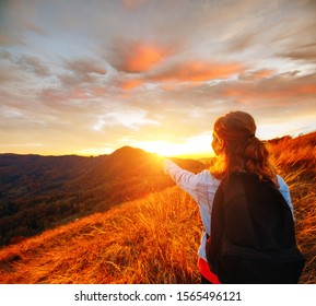 Carefree hipster girl enjoying nature with open arms to sunrise on mountain peak. Image of freedom concept. The model meditates while vacationing outdoors. Photo style instagram, vintage effect.  - Shutterstock ID 1565496121