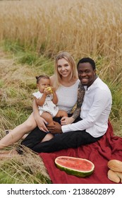 Carefree Mixed Race Family Having Picnic Outdoors In Sunny Day