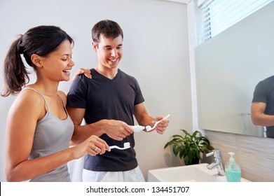 carefree real couple brushing teeth in the bathroom together. daily routine dental health - Powered by Shutterstock