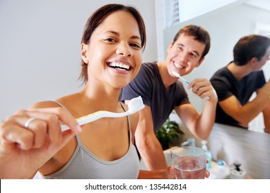carefree real couple brushing teeth in the bathroom together. daily routine dental health - Powered by Shutterstock