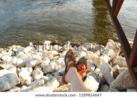 Carefree sandals near white rocks and river