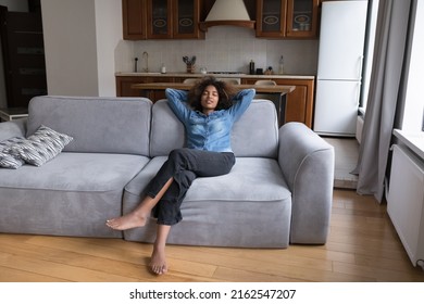 Carefree Sleepy Black Teen Girl Relaxing On Soft Couch, Stretching Body, Taking Deep Breath Of Fresh Air, Enjoying Silent Leisure Time At Comfortable Home, Practicing Stress Relief. Full Length