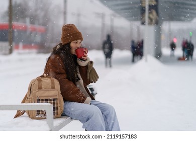 Carefree Traveler Girl Recreating With Hot Tea At Train Station Waiting For Transport Arrival And Departure For Winter Vacation. Young Asian Woman With Backpack Drink Coffee Beverage Travelling Alone