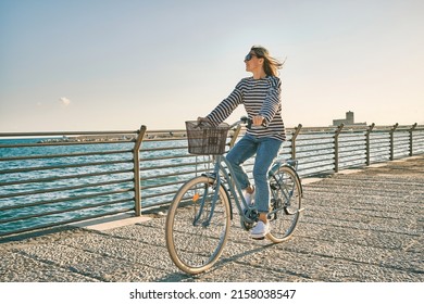 Carefree woman with bike riding on beach having fun, on the seaside promenade on a summer day. Summer Vacation. Travel and lifestyle Concept.
 - Powered by Shutterstock