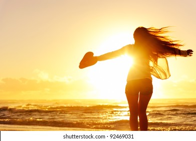 carefree woman dancing in the sunset on the beach. vacation vitality healthy living concept - Powered by Shutterstock