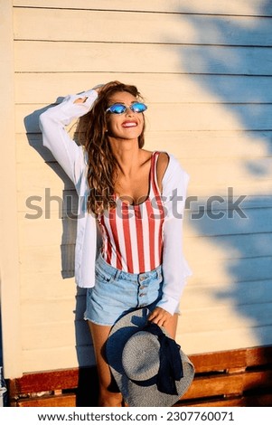 Similar – Young surfer woman with top and bikini kissing surfboard