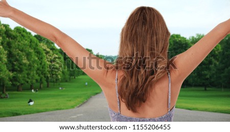 Carefree woman in a summer dress outside hair blowing in wind