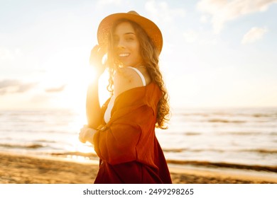 Carefree woman tourist walking along ocean sandy beach at sunset. Travel, weekend, relax and lifestyle concept. - Powered by Shutterstock