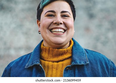 carefree young cheerful androgenic looking person with toothy smile close-up looking at camera - really confident hipster style person with piercing isolated on blurred background - body positives - Shutterstock ID 2136099459