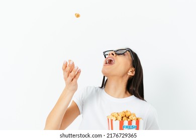 Carefree Young Woman In 3D Glasses Eating Popcorn Tossing It In Her Mouth, Having Fun While Watching Movie, White Studio Background