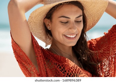 Carefree Young Woman At Beach Enjoying Summer Holiday. Portrait Of Happy Smiling Hispanic Woman Relaxing At Sea During Vacation. Close Up Face Of Beautiful Fashion Girl With Dress Walking On The Beach