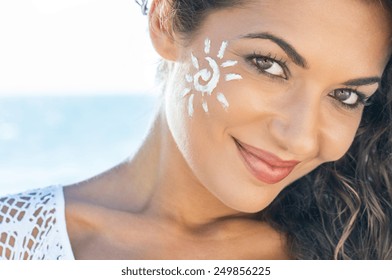 Carefree Young Woman With Suncream On Face At Beach