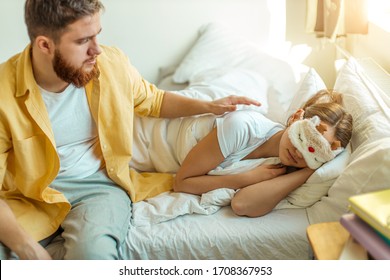 careful caucasian guy strike his girlfriend while she is sleeping on bed. man sit on bed next to woman before going to work