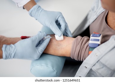 Careful Doctor Collecting Blood Sample From The Arm Of His Patient And Using Vacuum Collection Needle