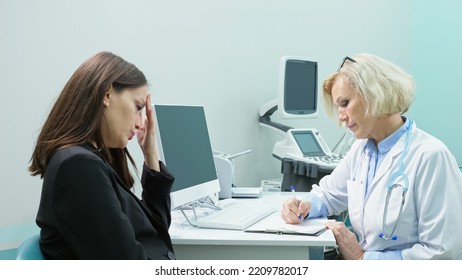 Careful Female Doctor Writes Prescription Listening To Symptoms Of Dejected Woman. Lady Patient Complains Of Migraine And Strong Headache In Ultrasound Room