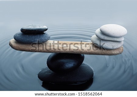 Carefully balanced black and white stones in water
