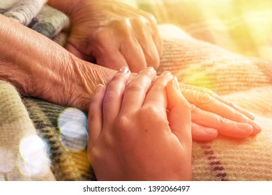 Caregiver, carer hand holding elder hand