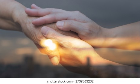 Caregiver, Carer Hand Holding Elder Hand In With City Urban Background. Philanthropy Kindness Medical Healthcare To Disabled Concept.