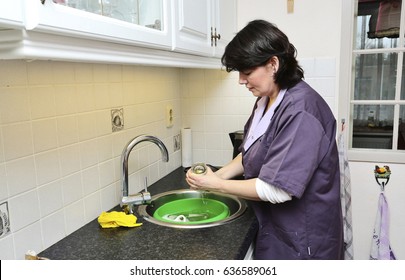 A Caregiver Is Doing The Dishes