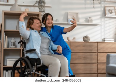 A caregiver and an elderly woman in a wheelchair taking a selfie together in a cozy home setting, showcasing companionship and home care. - Powered by Shutterstock