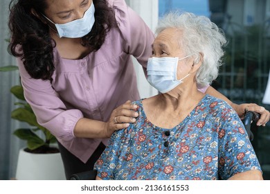 Caregiver Help Asian Senior Or Elderly Old Lady Woman Sitting On Wheelchair And Wearing A Face Mask For Protect Safety Infection Covid 19 Coronavirus.