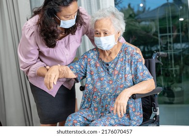 Caregiver Help Asian Senior Or Elderly Old Lady Woman Sitting On Wheelchair And Wearing A Face Mask For Protect Safety Infection Covid 19 Coronavirus.