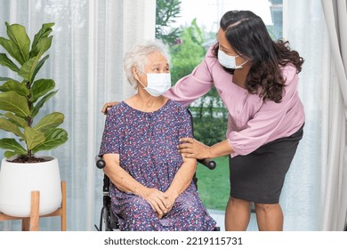 Caregiver Help Asian Senior Or Elderly Old Lady Woman Sitting On Wheelchair And Wearing A Face Mask For Protect Safety Infection Covid19 Coronavirus.